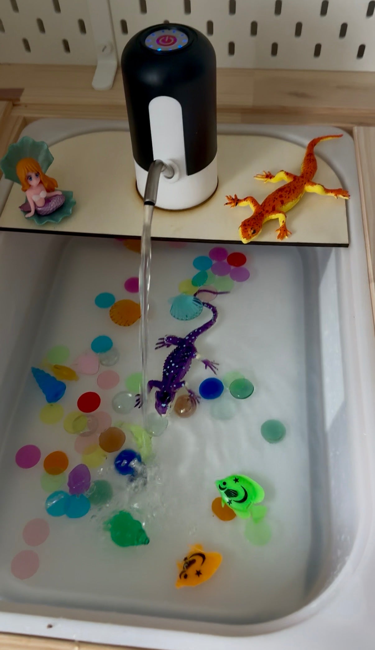 Vodní pumpa při smyslovém hraní s vodou a barevnými prvky